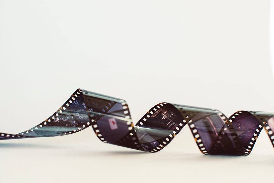 Close-up of a classic photographic film strip with a vintage feel against a white background.